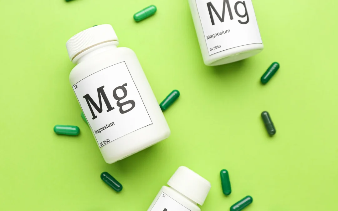 A variety of types of magnesium bottles and pills scattered on a green background, showcasing different types of magnesium and their benefits for health and wellness.